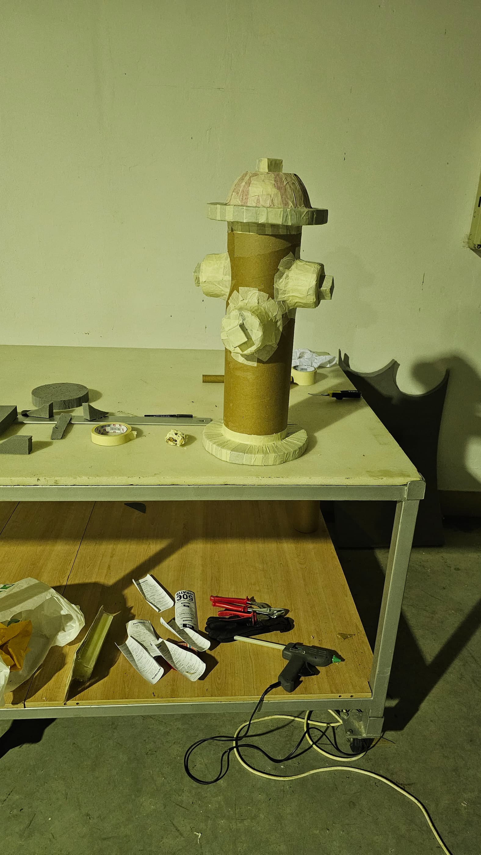 La pieza en bruto sobre la mesa del taller: el tubo de cartón y la espuma, antes de pintar.