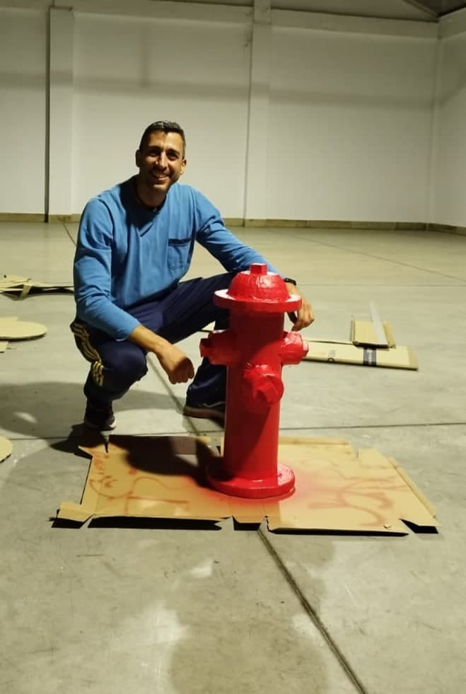 Una persona agachada junto a la boca de riego terminada da la medida real de la pieza.