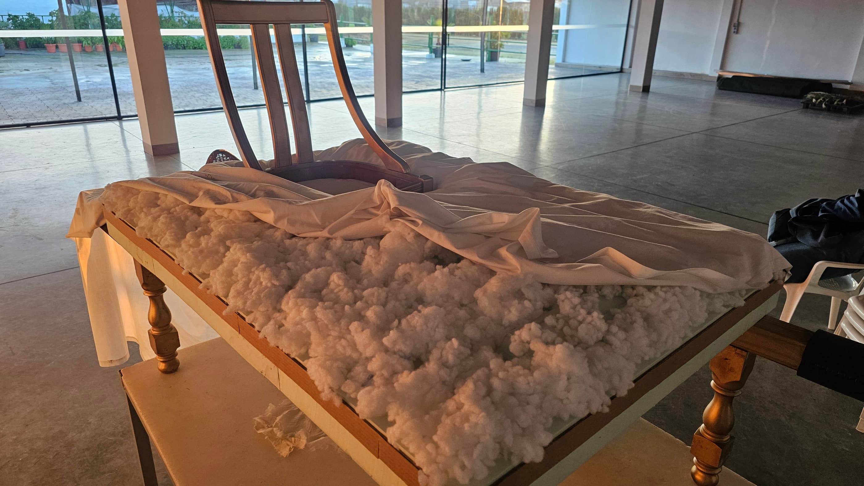 El asiento del trono durante el tapizado, con el relleno y la tela blanca a medio colocar.